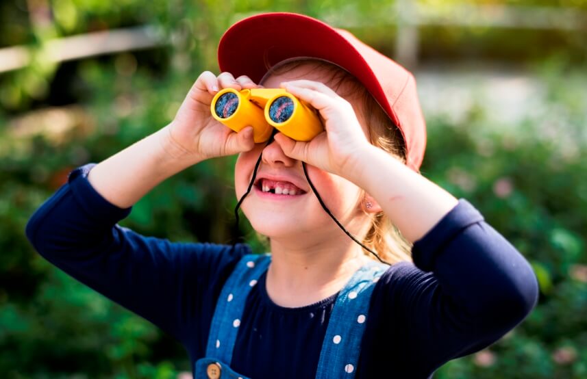 kid in a garden with a binocular