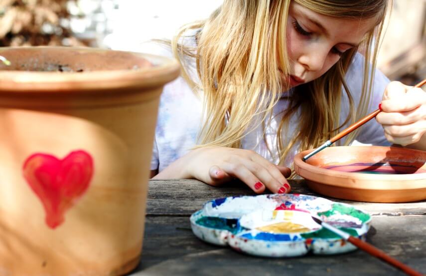 a kid painting Terracotta Pots